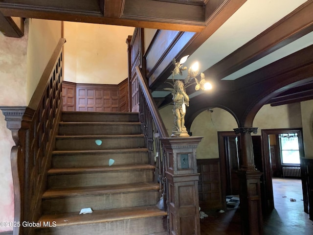 1077 University Pl, Schenectady, NY 12308 - stairs featuring radiator heating unit, a decorative wall, arched walkways, and a wainscoted wall