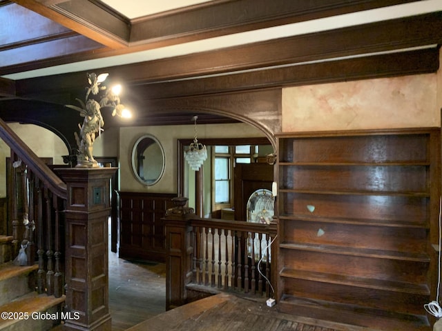 1077 University Pl, Schenectady, NY 12308 - stairs featuring wood finished floors, a chandelier, arched walkways, a wainscoted wall, and beamed ceiling