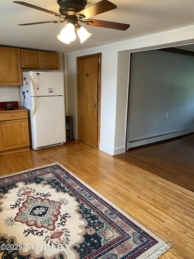 162 Garnet Lake Rd, Thurman, NY 12885 - kitchen featuring freestanding refrigerator, a baseboard radiator, ceiling fan, brown cabinets, and light wood-type flooring