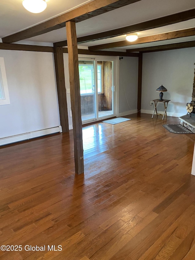 162 Garnet Lake Rd, Thurman, NY 12885 - empty room with beamed ceiling, wood finished floors, a baseboard heating unit, baseboards, and a wood stove