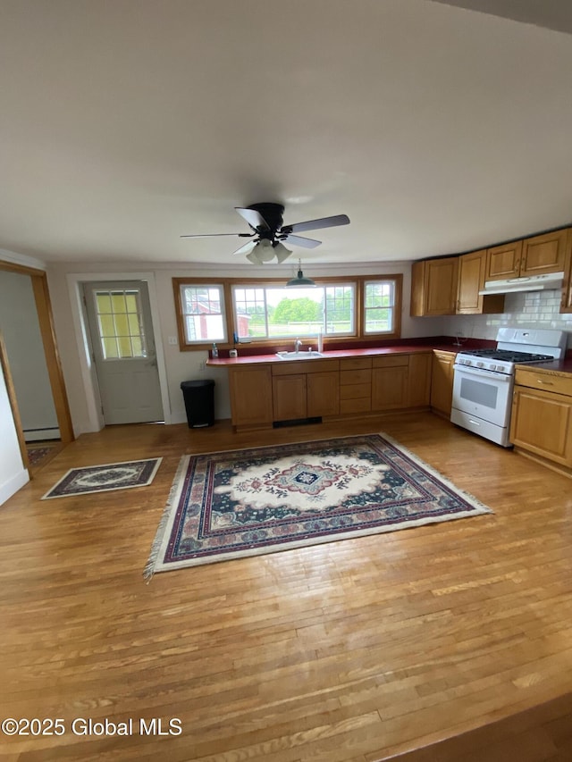 162 Garnet Lake Rd, Thurman, NY 12885 - kitchen featuring white gas stove, under cabinet range hood, light wood finished floors, and baseboard heating
