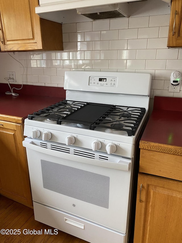 162 Garnet Lake Rd, Thurman, NY 12885 - kitchen with gas range gas stove, decorative backsplash, wood finished floors, and brown cabinetry