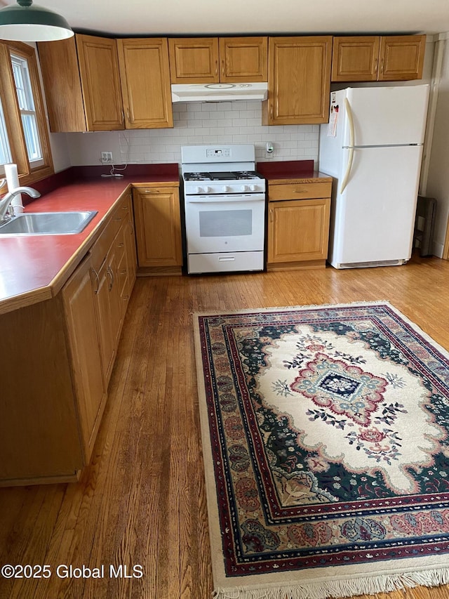 162 Garnet Lake Rd, Thurman, NY 12885 - kitchen with white appliances, under cabinet range hood, light wood-style flooring, a sink, and dark countertops