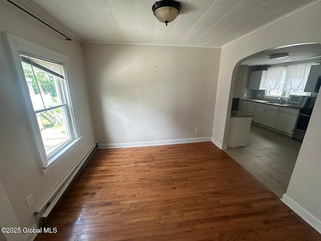 4 Ball Pl, Watervliet, NY 12189 - unfurnished dining area with ornamental molding, arched walkways, a baseboard heating unit, wood finished floors, and baseboards