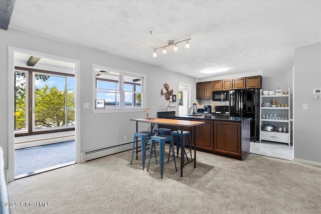527 Nys Route 9p, Stillwater, NY 12866 - kitchen with a baseboard heating unit, black appliances, light carpet, dark countertops, and a textured ceiling
