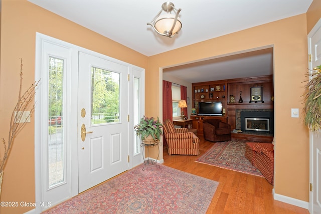 1832 Union St, Niskayuna, NY 12309 - entryway with wood finished floors, a glass covered fireplace, and baseboards
