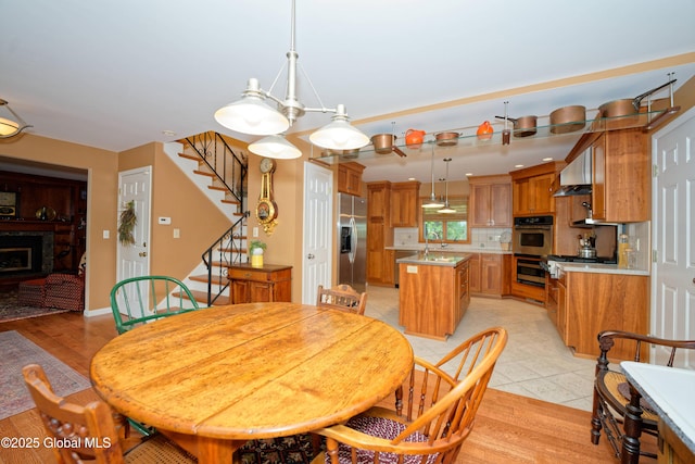 1832 Union St, Niskayuna, NY 12309 - dining area with stairs, light tile patterned floors, and a fireplace