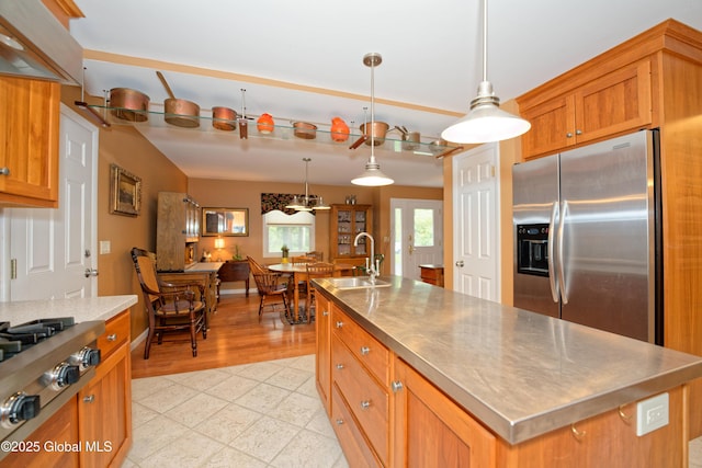 1832 Union St, Niskayuna, NY 12309 - kitchen featuring a sink, appliances with stainless steel finishes, a center island with sink, brown cabinetry, and pendant lighting