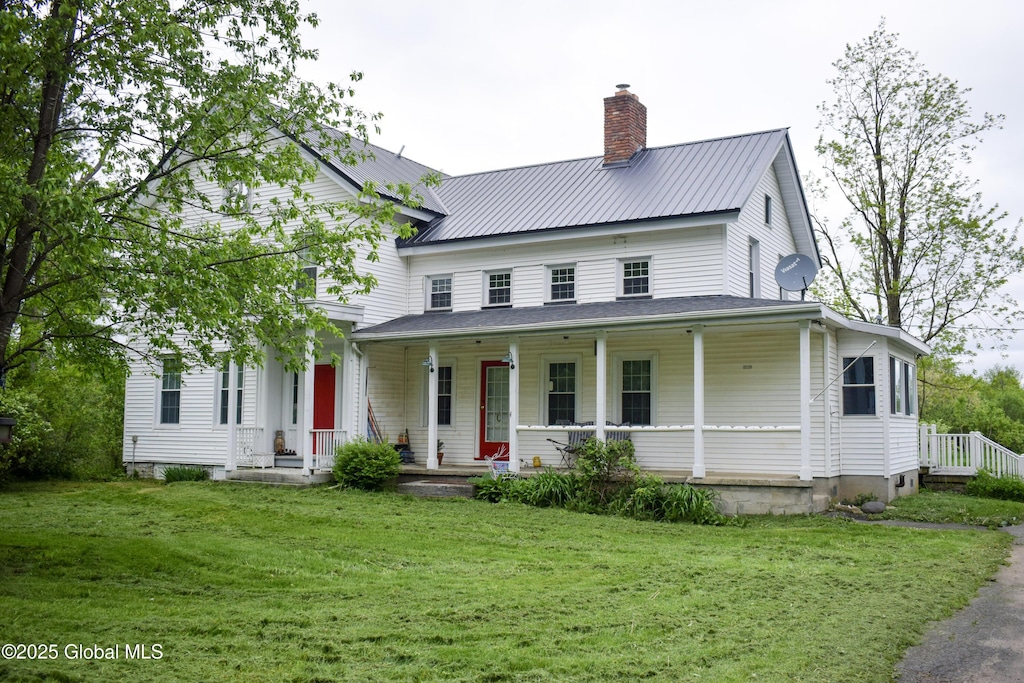 219 Oswegatchie Rd, Mohawk, NY 12068 - view of front of home with a chimney, covered porch, a front lawn, and metal roof