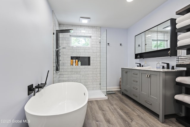 91 Gorman Rd, Menands, NY 12204 - bathroom with double vanity, a tile shower, a freestanding tub, wood finished floors, and baseboards