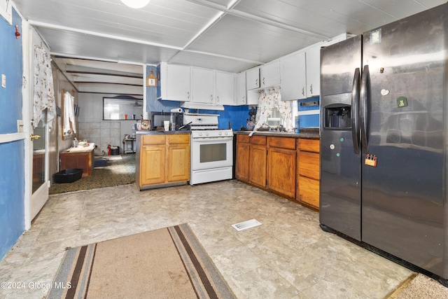20 Vincek Ln, Wilton, NY 12866 - kitchen with stainless steel refrigerator with ice dispenser, white range with gas stovetop, dark countertops, under cabinet range hood, and white cabinets