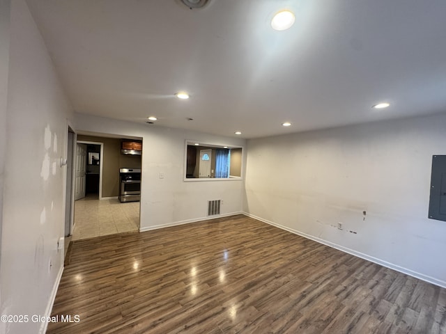 54 Sargent St, Cohoes, NY 12047 - unfurnished living room with wood finished floors, baseboards, recessed lighting, and electric panel