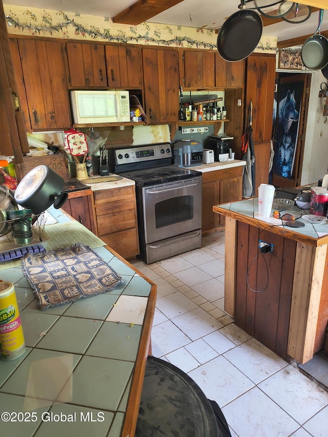 479 Junction Rd, Esperance, NY 12066 - kitchen with stainless steel range with electric stovetop, white microwave, tile countertops, and brown cabinets