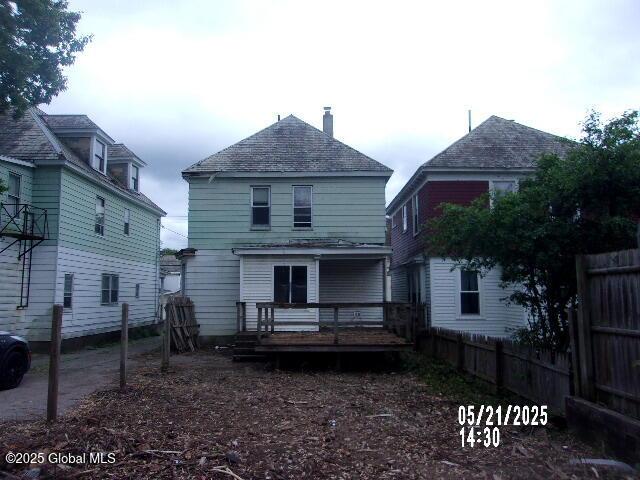 1745 Becker St, Schenectady, NY 12304 - rear view of house featuring a wooden deck, a fenced backyard, roof with shingles, and a chimney