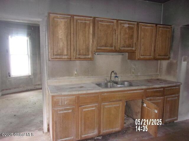 1745 Becker St, Schenectady, NY 12304 - kitchen featuring a sink, tile countertops, and brown cabinetry