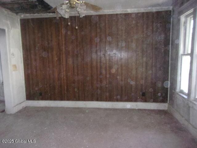 1745 Becker St, Schenectady, NY 12304 - unfurnished room featuring wooden walls, plenty of natural light, and a ceiling fan