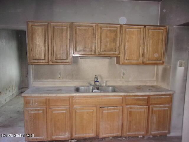 1745 Becker St, Schenectady, NY 12304 - kitchen with a sink, light countertops, and brown cabinetry