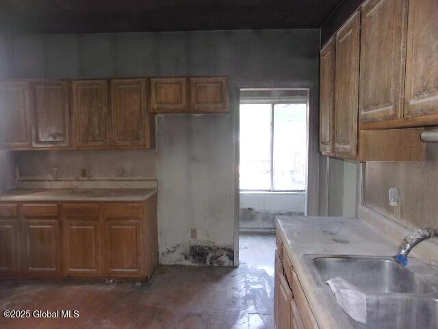 1745 Becker St, Schenectady, NY 12304 - kitchen with a sink, light countertops, and brown cabinets