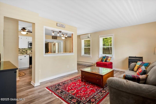 113 New Vermont Rd, Bolton, NY 12814 - living area featuring a wall mounted air conditioner, a baseboard radiator, a wood stove, wood finished floors, and baseboards