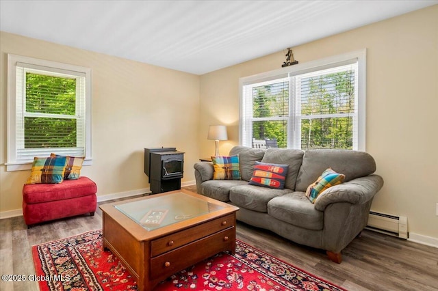 113 New Vermont Rd, Bolton, NY 12814 - living room featuring a wood stove, plenty of natural light, a baseboard heating unit, and wood finished floors