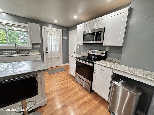 134 Moyer St, Canajoharie, NY 13317 - kitchen with stainless steel appliances, a sink, light wood-type flooring, white cabinets, and recessed lighting