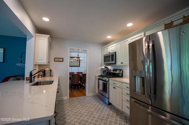 95 Jordan Blvd, Bethlehem, NY 12054 - kitchen with appliances with stainless steel finishes, a sink, a chandelier, white cabinetry, and baseboards