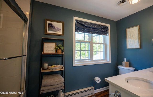 95 Jordan Blvd, Bethlehem, NY 12054 - full bathroom featuring a baseboard heating unit, a shower with shower door, vanity, and toilet
