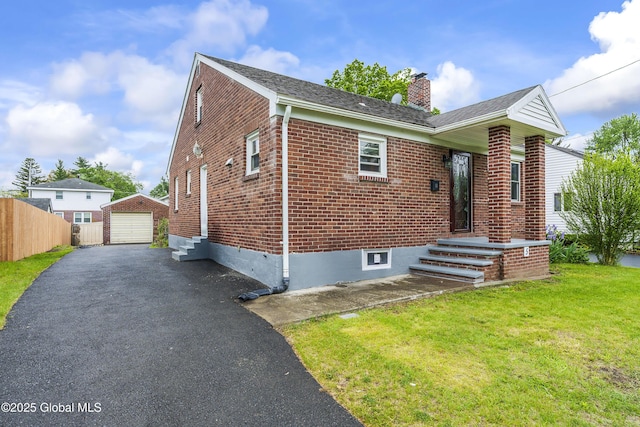 5 Brigadier St, Colonie, NY 12205 - view of front of home featuring asphalt driveway, brick siding, a chimney, a garage, and an outdoor structure