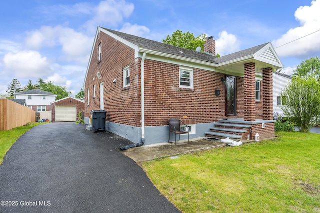 5 Brigadier St, Colonie, NY 12205 - view of front facade with asphalt driveway, a chimney, brick siding, a garage, and an outdoor structure