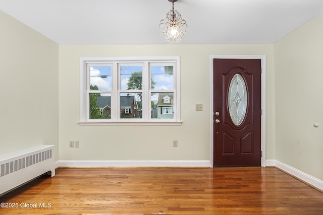 5 Brigadier St, Colonie, NY 12205 - entrance foyer with radiator heating unit, wood finished floors, baseboards, and a chandelier