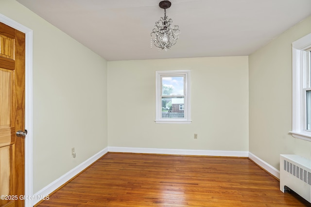 5 Brigadier St, Colonie, NY 12205 - unfurnished room with radiator, healthy amount of natural light, wood finished floors, and a chandelier
