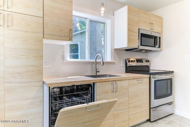3956 Rte 9 W, Saugerties, NY 12477 - kitchen featuring stainless steel appliances, light brown cabinetry, a sink, and tasteful backsplash