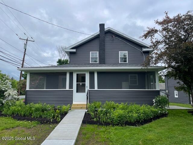 3916 State Highway 2, Brunswick, NY 12180 - view of front of property featuring a sunroom, a chimney, a shingled roof, and a front lawn