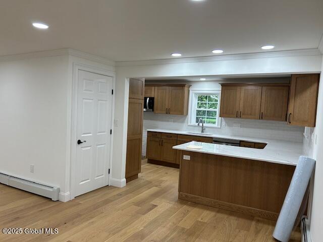 3916 State Highway 2, Brunswick, NY 12180 - kitchen with a baseboard heating unit, a sink, crown molding, light wood-style flooring, and a peninsula