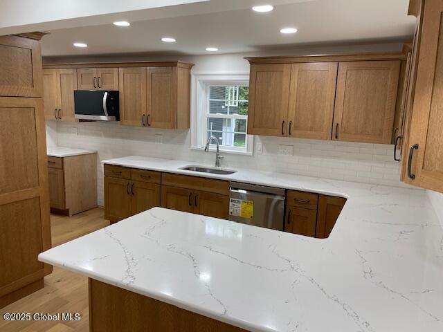 3916 State Highway 2, Brunswick, NY 12180 - kitchen with appliances with stainless steel finishes, a sink, light stone countertops, brown cabinetry, and recessed lighting