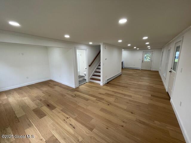 3916 State Highway 2, Brunswick, NY 12180 - below grade area featuring a baseboard radiator, stairway, light wood-type flooring, recessed lighting, and baseboards