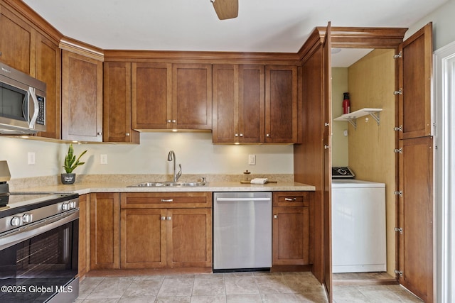 11 Thatcher Dr, Altamont, NY 12009 - kitchen featuring appliances with stainless steel finishes, washer / dryer, brown cabinetry, and light stone counters