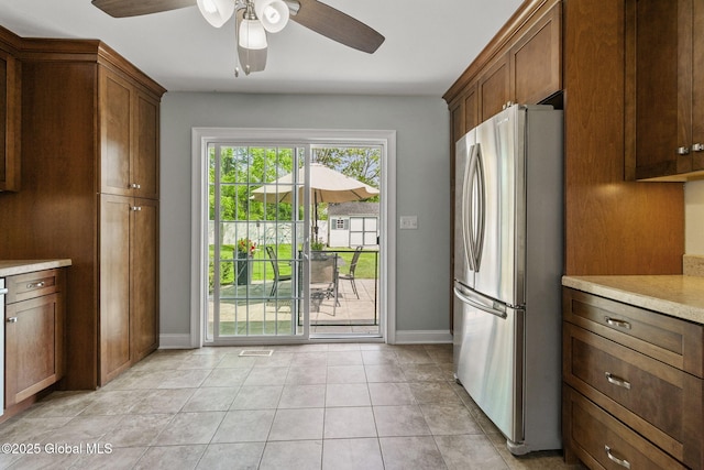 11 Thatcher Dr, Altamont, NY 12009 - kitchen featuring freestanding refrigerator, light countertops, ceiling fan, light tile patterned flooring, and brown cabinets