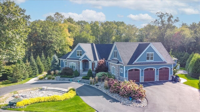 18 Rose Ter, Wilton, NY 12866 - view of front of property with asphalt driveway, stone siding, and a garage