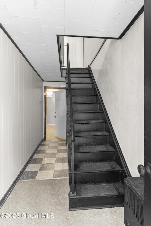 819 1st St, Rensselaer, NY 12144 - stairway with tile patterned floors and wood walls