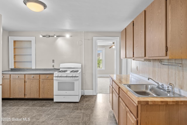819 1st St, Rensselaer, NY 12144 - kitchen featuring white gas range, a sink, a ceiling fan, and baseboards