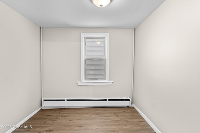 819 1st St, Rensselaer, NY 12144 - spare room with a baseboard heating unit, wood finished floors, and baseboards
