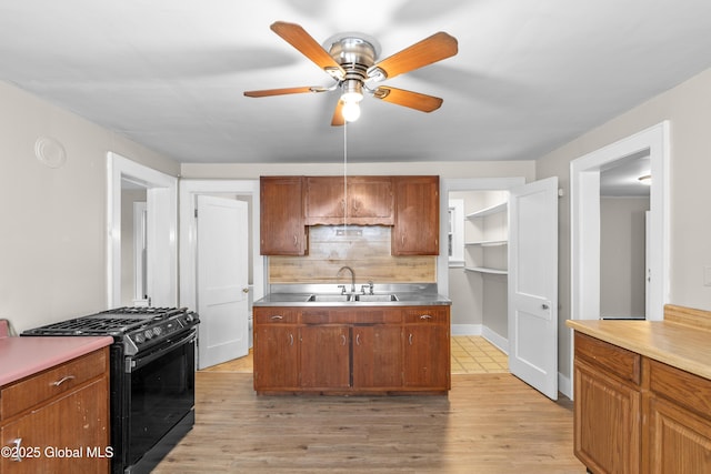 819 1st St, Rensselaer, NY 12144 - kitchen featuring black range with gas stovetop, a sink, tasteful backsplash, ceiling fan, and light wood-type flooring