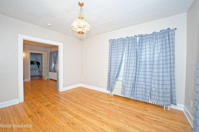 1013 Washington Ave, Albany, NY 12206 - empty room featuring a chandelier, light wood-style floors, and baseboards