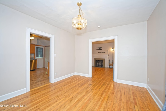 1013 Washington Ave, Albany, NY 12206 - unfurnished room with light wood-style flooring, a chandelier, a fireplace, and baseboards