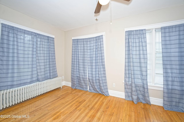 1013 Washington Ave, Albany, NY 12206 - unfurnished room featuring radiator heating unit, wood finished floors, ceiling fan, and baseboards