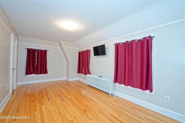 1013 Washington Ave, Albany, NY 12206 - empty room featuring radiator heating unit, wood finished floors, vaulted ceiling, and baseboards