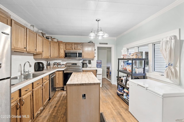 1022 State Route 29, Greenwich, NY 12834 - kitchen featuring stainless steel appliances, crown molding, a sink, a kitchen island, and a chandelier