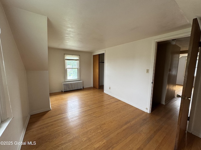 46 Elmhurst Ave, Albany, NY 12203 - unfurnished bedroom with radiator, light wood-style flooring, a closet, and baseboards
