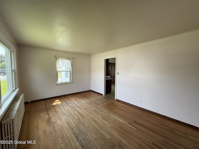 46 Elmhurst Ave, Albany, NY 12203 - spare room with radiator heating unit, dark wood-style flooring, baseboards, and ornamental molding